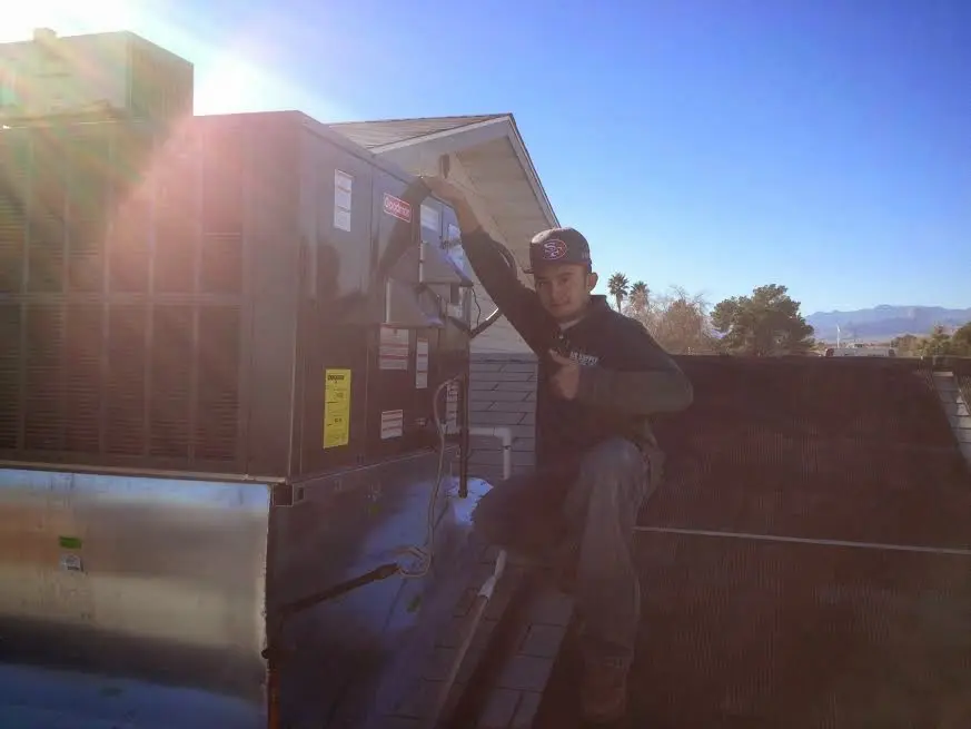 HVAC technician performing Air Duct Cleaning on a rooftop unit in Bismarck